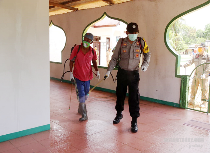 Anggota Polres Bintan saat menyemprotkan cairan disinfektan disalah satu rumah ibadah di Bintan